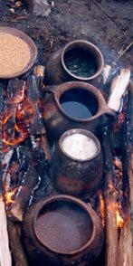 Koken in aardewerk potten - het vuur aan beide kanten. (klik voor een uitvergroting)